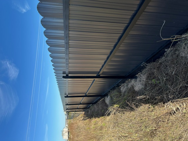Long run of grey steel fence on an open lot near Houston